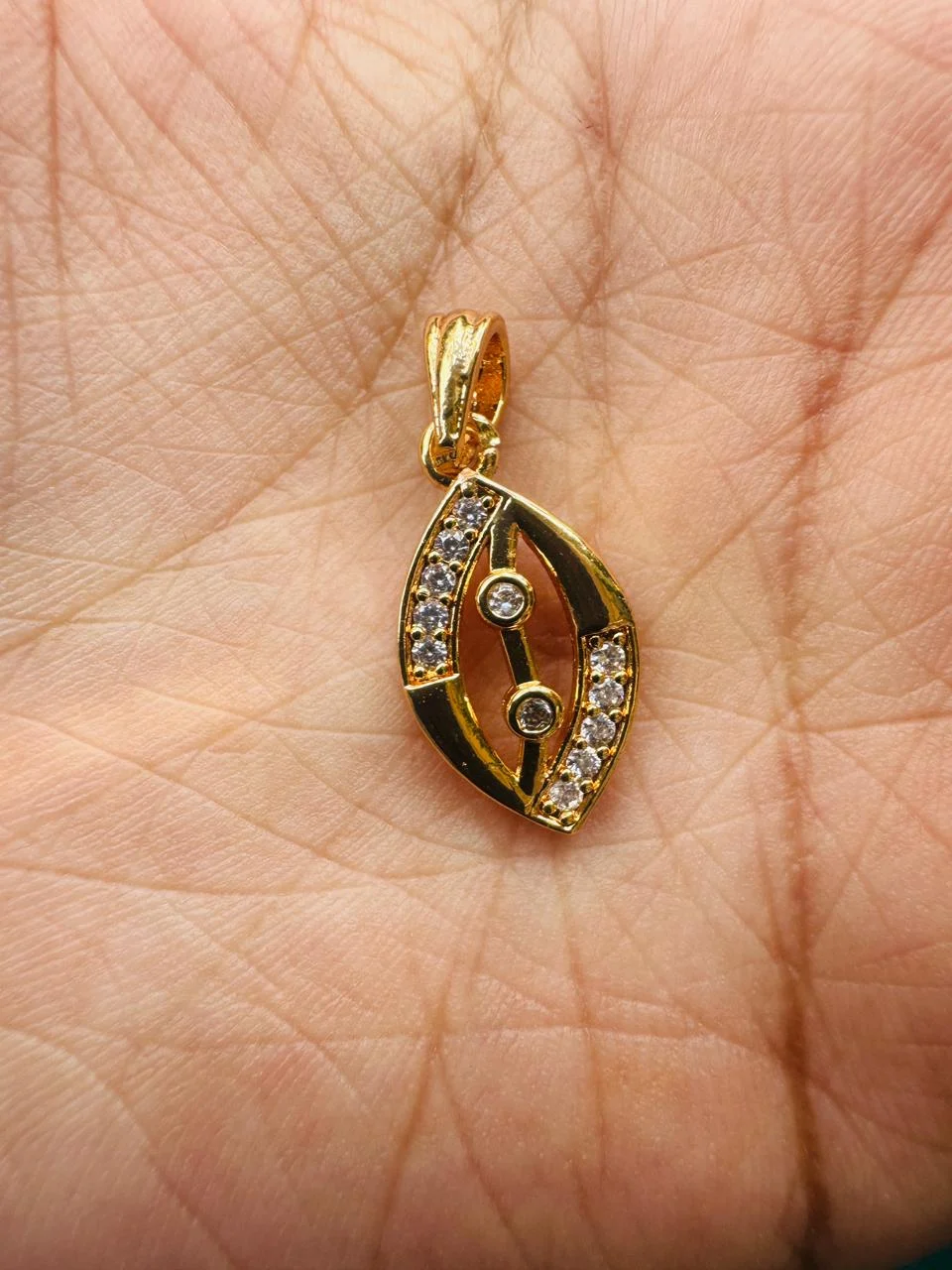 Gold plated new stylish rich look EYE design oval pendent with white stones for women and Girl
